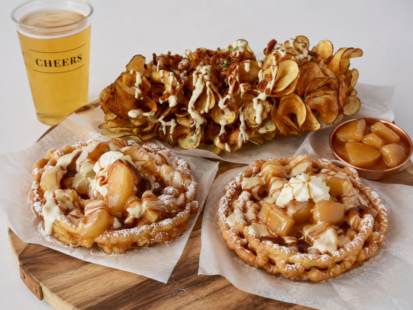 Loaded fries and fresh funnel cakes served together at a White Mountain Food Co event.